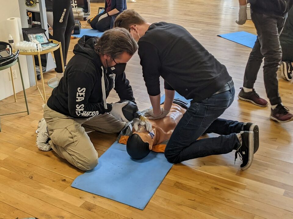 man in gray long sleeve shirt and black pants sitting on brown wooden floor